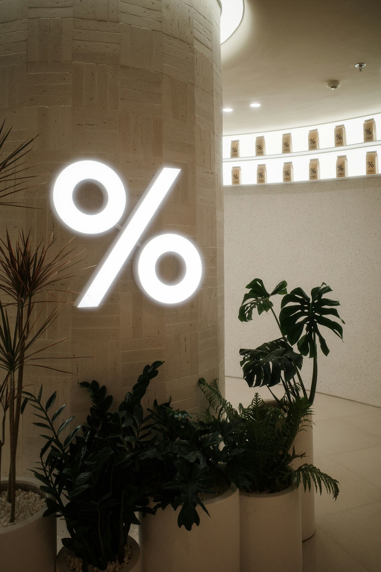 A lighted percent sign decorates a cafe interior.